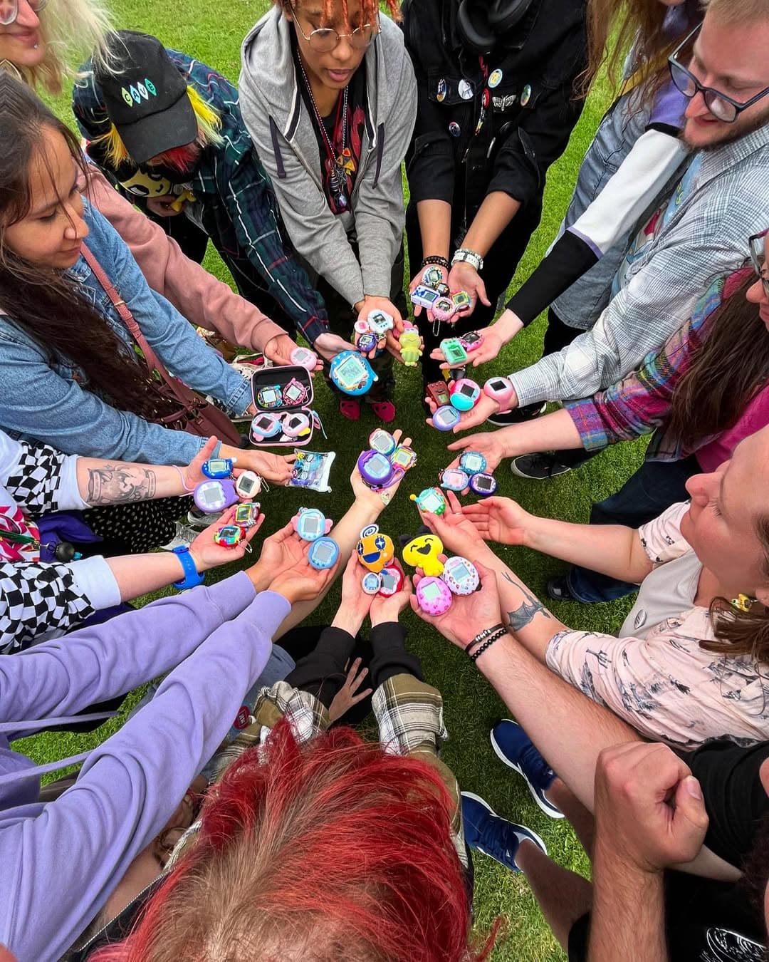 A group of people in a circle holding Tamagotchis